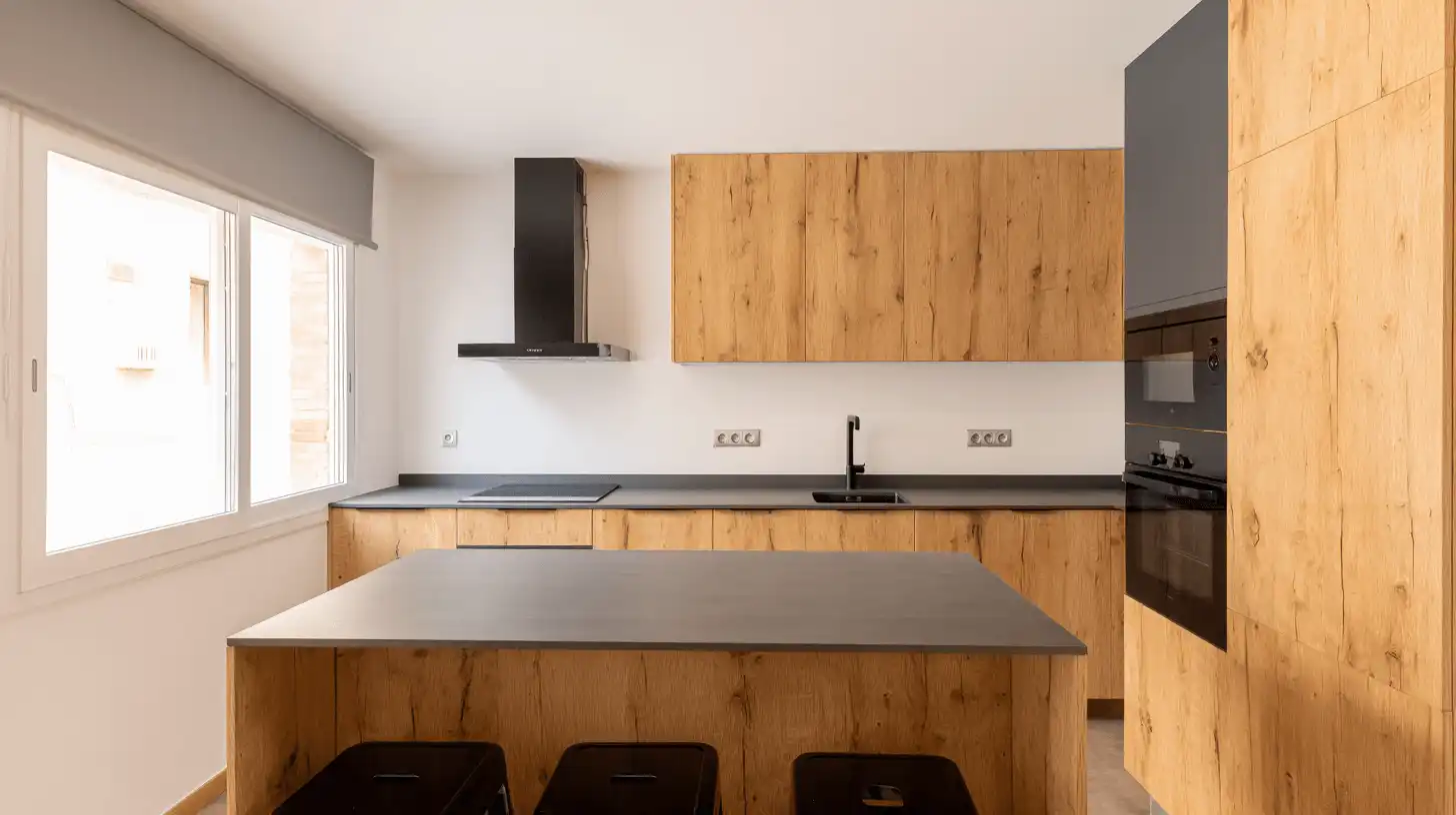 Reforma de cocina de madera con isla central en una vivienda de Sabadell